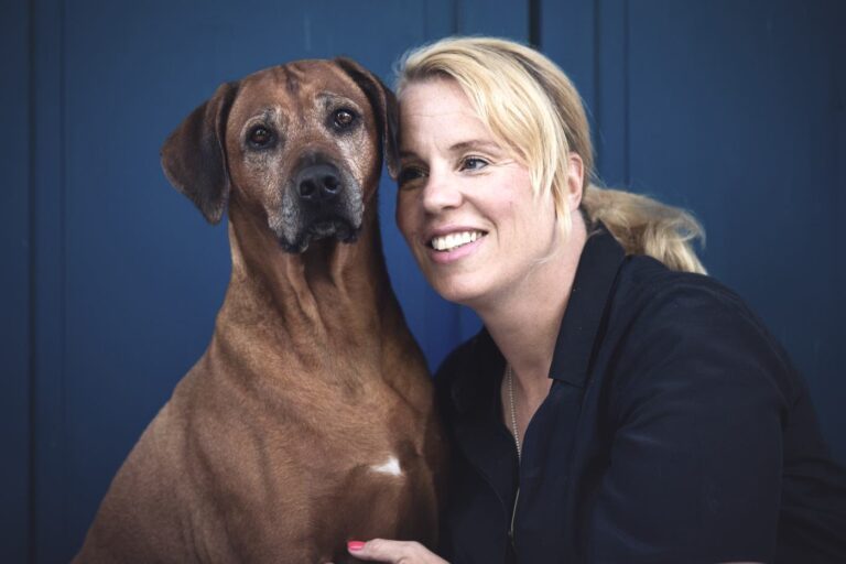 Steffi Diem mit Hündin Lila vor blauer Tür