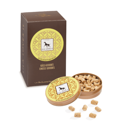 elegante braune und gelbe Faltschachtel steht neben einer gelben Metall-Dose mit Leckerli für Hunde aus Käse mit geöffnetem Deckel und davorliegenden exemplarischen Leckerli auf transparentem Hintergrund | LILA LOVES IT "Käse-Goodies"