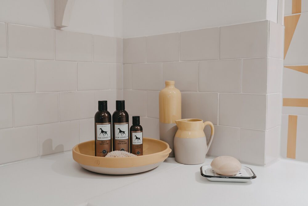 Shampoo_Shine & Comb_Fellkur-Silky&Shine_Shampoo-Sensitive im gelb Ambiente in einem Waschraum mit Olivenseife
