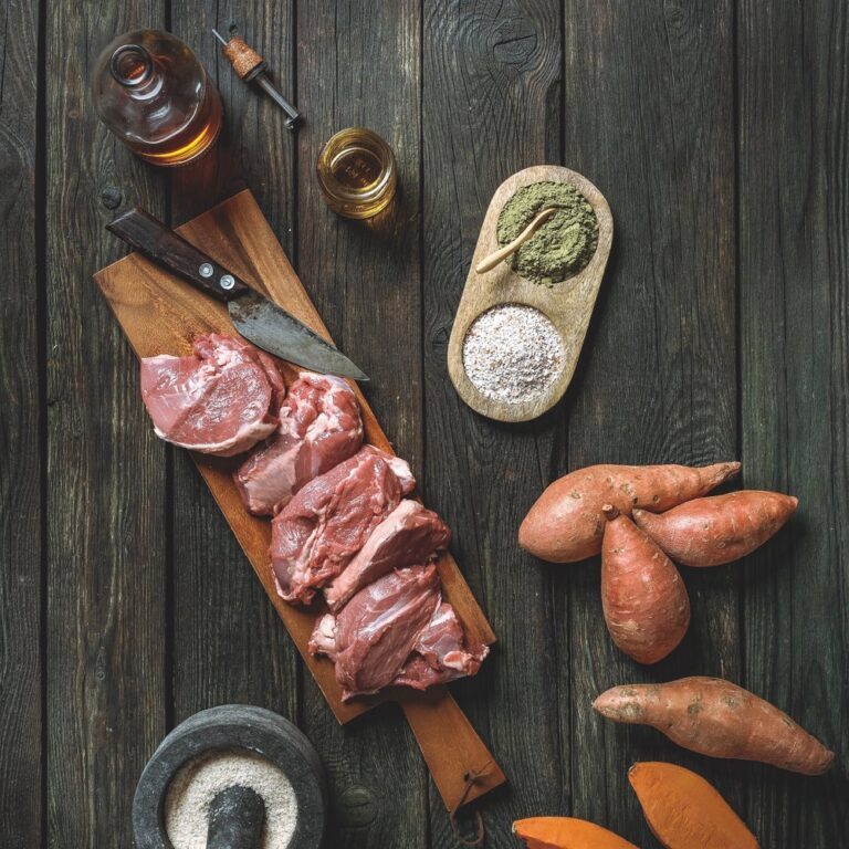 Zutaten für Nassfutter aus Lammfleisch präsentiert auf einem Holzbrett auf einem dunklen Holz Untergrund | LILA LOVES IT "Nassfutter aus Lammfleisch"