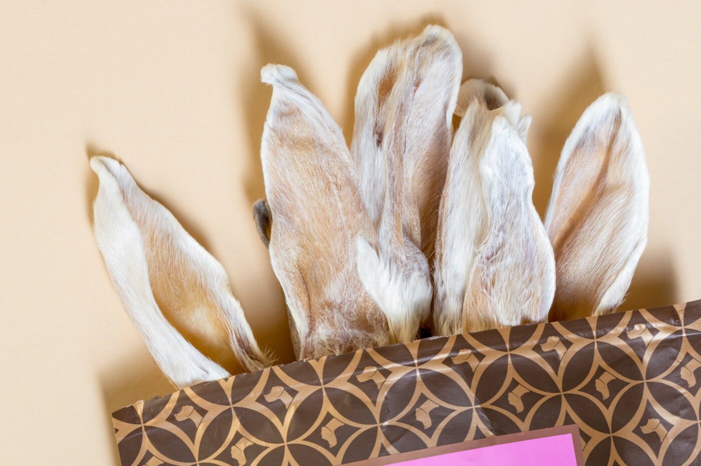 Kausnack für Hunde aus Kaninchen-Ohren mit Verpackung auf beigem Hintergrund | LILA LOVES IT "Kaninchen-Ohren"