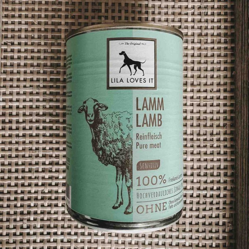 Grüne Metall-Dose in elegantem Design für Hundefutter aus Lammfleisch für BARF präsentiert auf auf einem beigen Bast-Hintergrund | LILA LOVES IT "Reinfleisch Lamm"